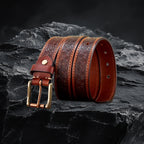 Echtleder-Gurt für Herren in Khaki – gerollt mit Metallschnalle auf schwarzem Steinfelsen