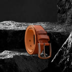 Echtleder-Gürtel aus braunem Rindsleder auf schwarzem Steinfelsen – Rückansicht am Gürtelende