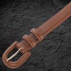 Echtleder-Gurt für Damen aus braunem Rindsleder auf schwarzem Steinfelsen – Detailansicht der Schnalle