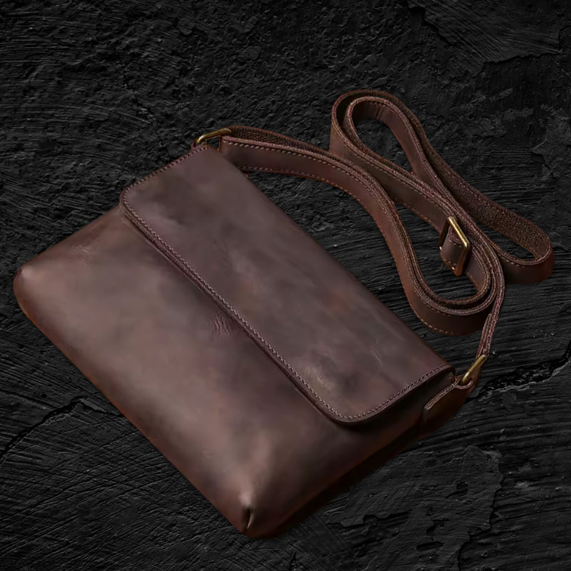 Echtleder Umhängetasche Herren aus Rindsleder – aufgelegt auf schwarzem Stein mit sichtbarem Schulterriemen