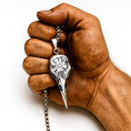 Wikinger Raben Halskette mit Vegvisir Rune aus Edelstahl – gehalten in einer kräftigen Wikingerhand, Symbol für Stärke, Mut und nordische Macht.