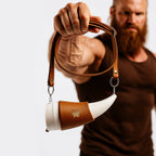 Wikinger Thermobecher im Horn-Design – weißer Kaffeebecher mit braunem Lederhalter, präsentiert von starkem Mann