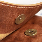 Detailaufnahme des Magnetverschlusses der Umhängetasche aus echtem Rindsleder – Modell ODIN in Braun, handgefertigt mit präziser Naht und Messingbeschlägen im Nordskulls Stil