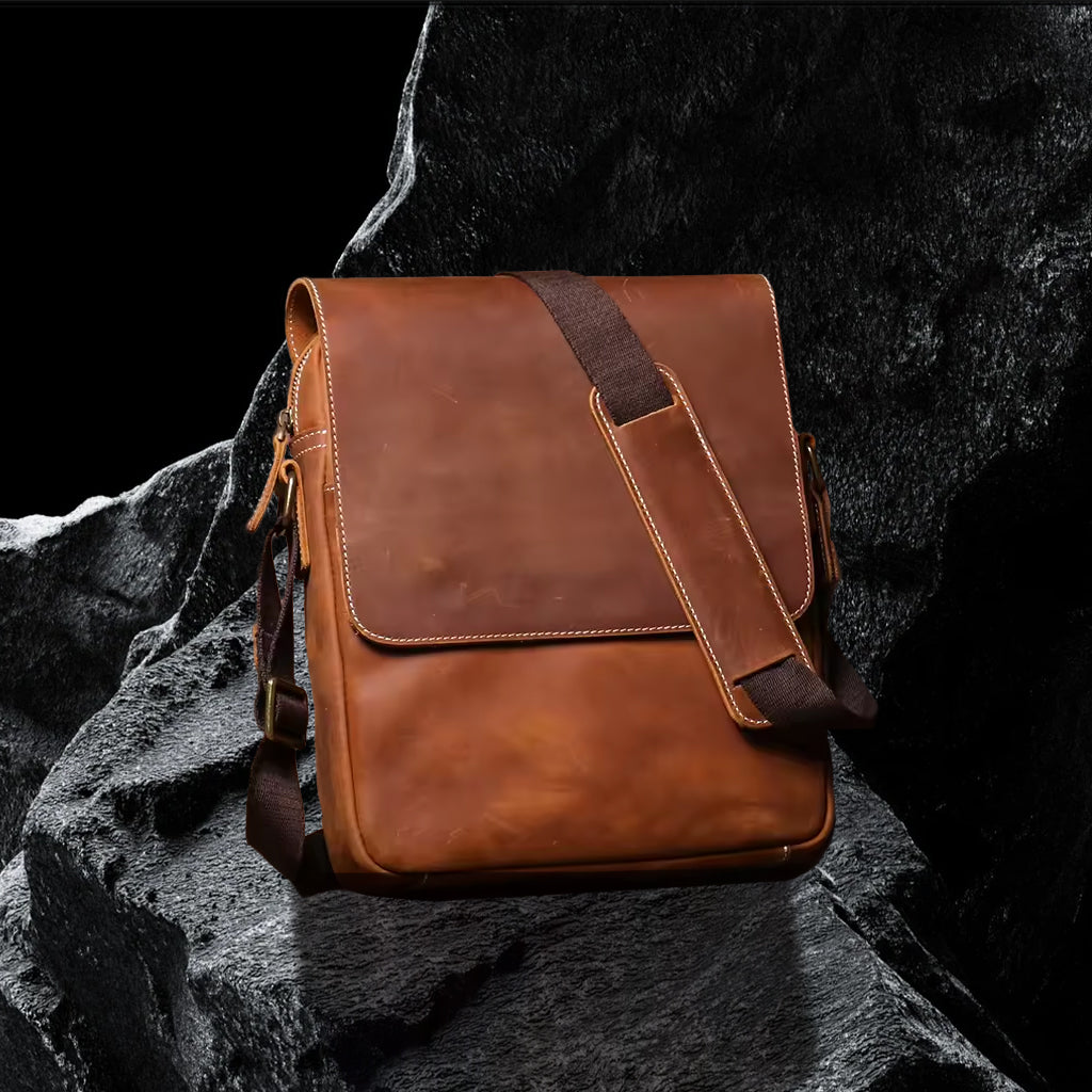 Umhängetasche aus Echtleder – schräge Frontansicht auf schwarzem Steinfelsen