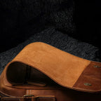 Umhängetasche aus Echtleder – geöffnete Ansicht auf schwarzem Steinfelsen