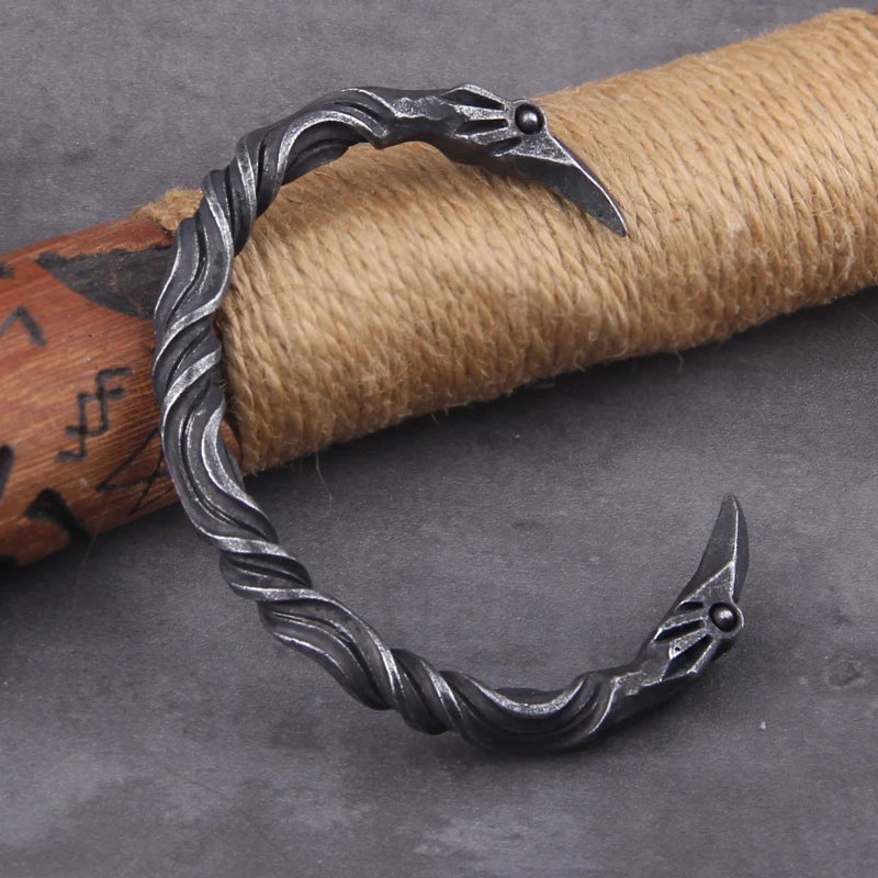 Nordischer Schmuck Armring VIKING-OATH – Edelstahl-Armreif im Raben-Design, platziert auf Wikinger-Requisite