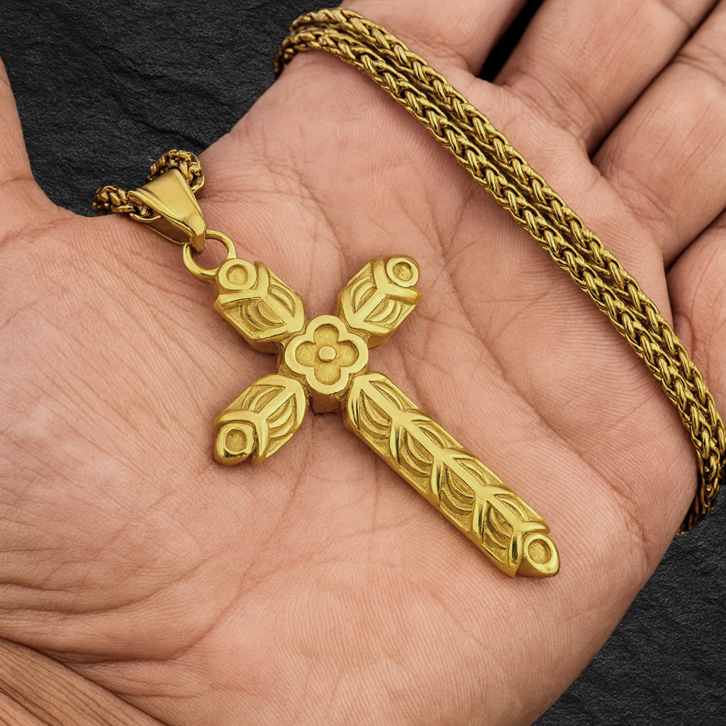 Wikinger Halskette RAGNARS CROSS in Gold, detailreich verziert, gehalten in einer Wikinger Hand.