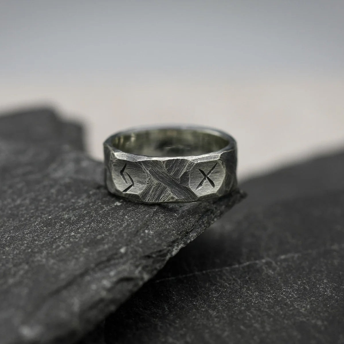 Runenring Wikinger Schmuck – Edelstahl Ring mit Runen auf dunkler Schieferplatte