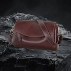 Echtleder Umhängetasche Damen in Braun aus echtem Leder auf dunklem Fels-Hintergrund