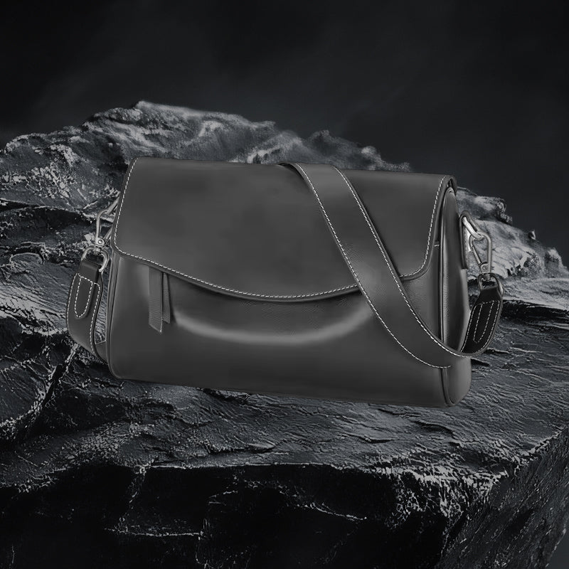 Echtleder Umhängetasche Damen in Schwarz aus echtem Leder auf dunklem Fels-Hintergrund