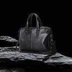 Herren Echtleder Tasche schwarz, robuste Business Ledertasche aus echtem Leder auf schwarzem Felsen